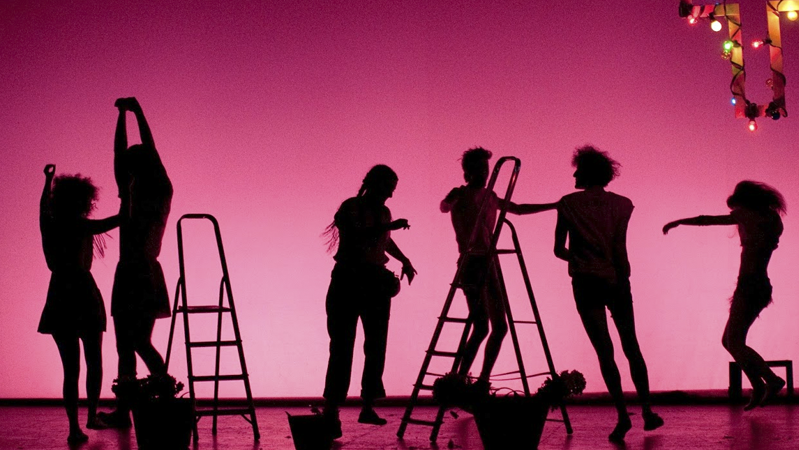 actores de teatro a contraluz delante de un fondo rosa