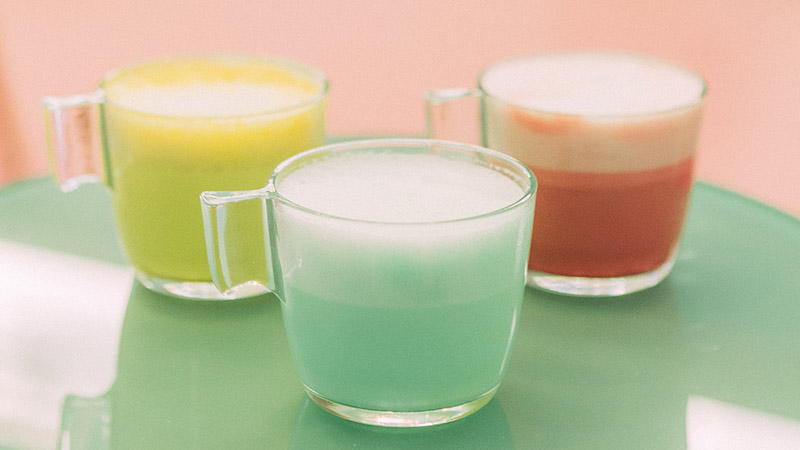 tazas con cafés de colores, amarillo, azul y rosa