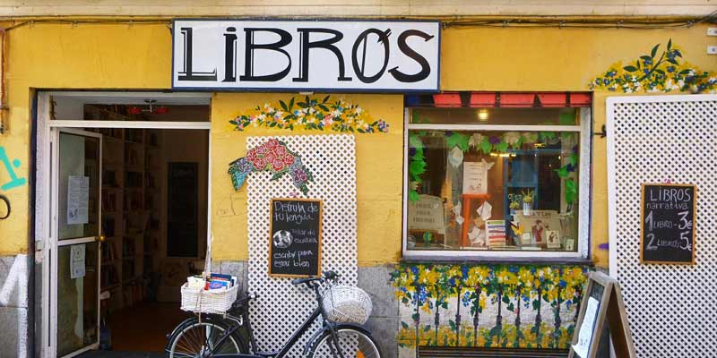 Fachada de la librería 'Libros para un mundo mejor' con una bicicleta en la entrada