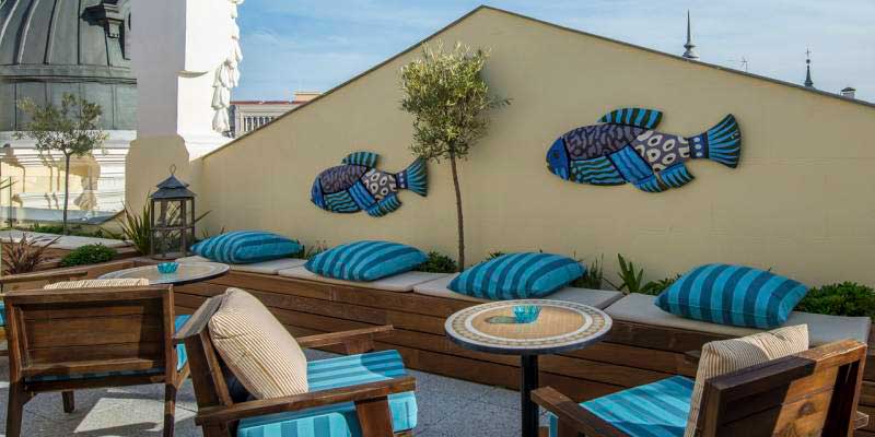 área de la terraza madrileña de The Mint decorada con peces y cojines azules