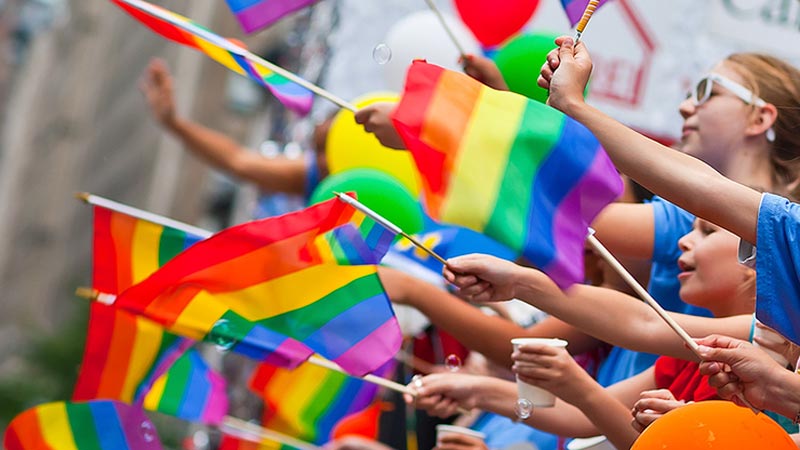  Personas ondeando banderas del movimiento LGTBI+.