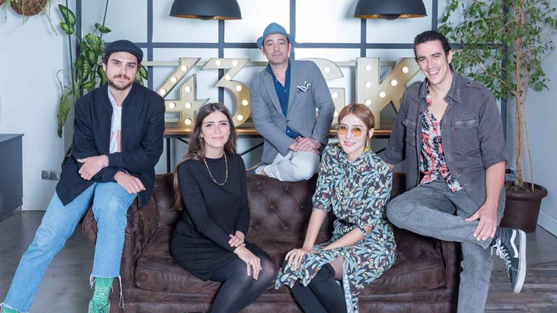 artistas de kasas posando sentados en el sofá