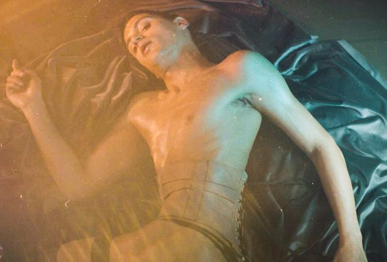 artista arca posando en una cama