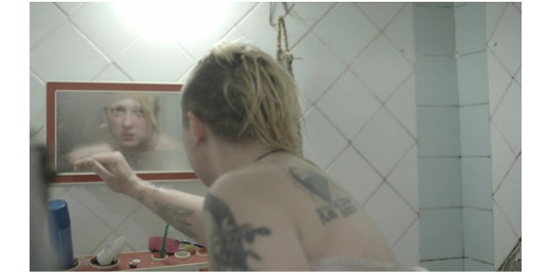 Mujer después de una ducha mirándose en el espejo