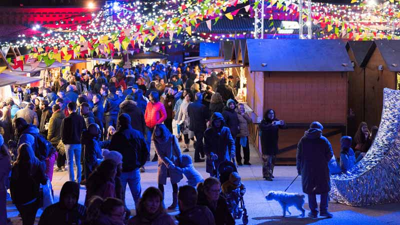 Mercado navideño lleno de gente y luces en Matadero