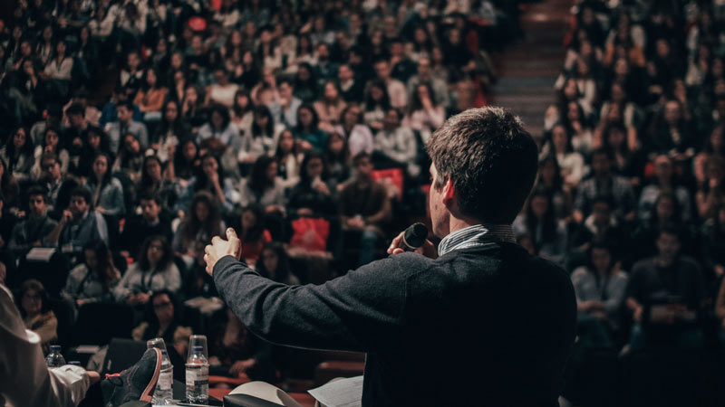 Ponente hablando a una multitud en una mesa de debate