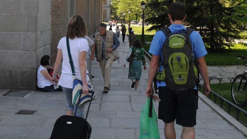 Turistas llevando maletas en el Paseo del Prado