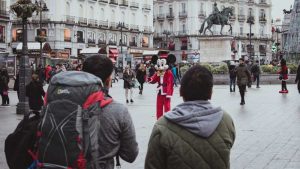 Pareja de turistas en la plaza de Sol en Madrid mirando a un personaje de dibujos