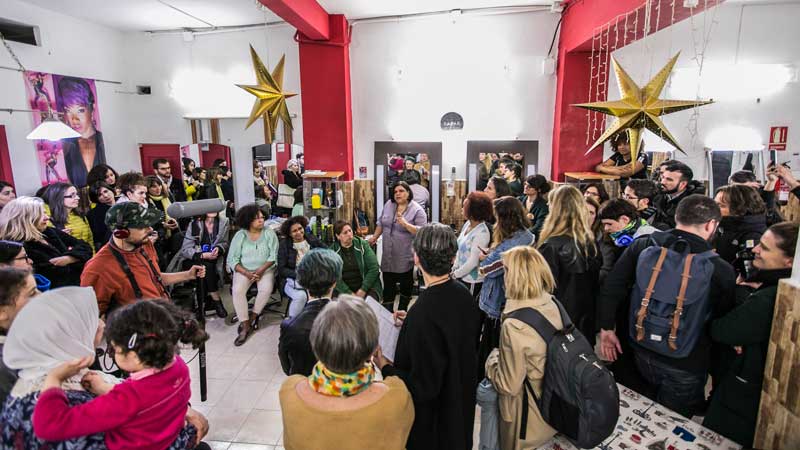 Grupo de gente agolpados en una peluquería donde se habla de la influencia de las mujeres en su comunidad