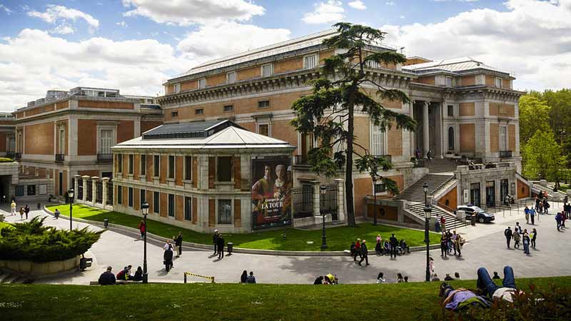 Visión general del museo del Prado desde el lado izquierdo, dos personas tumbadas en el césped