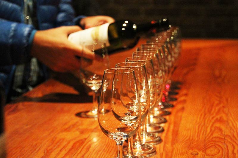 muchas copas de vino y alguien sirviendo vino-cata de vinos