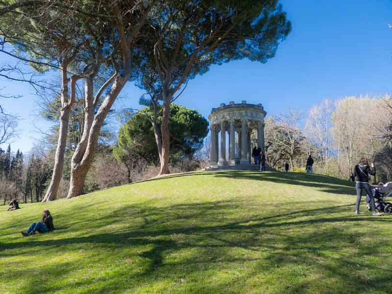 Monumento en un parque de Madrid, rodeado de árboles.