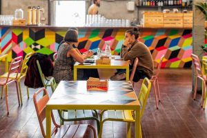 Dos personas sentadas en una mesa de una cafetería.