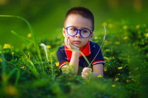 niño con gafas azules en jardín